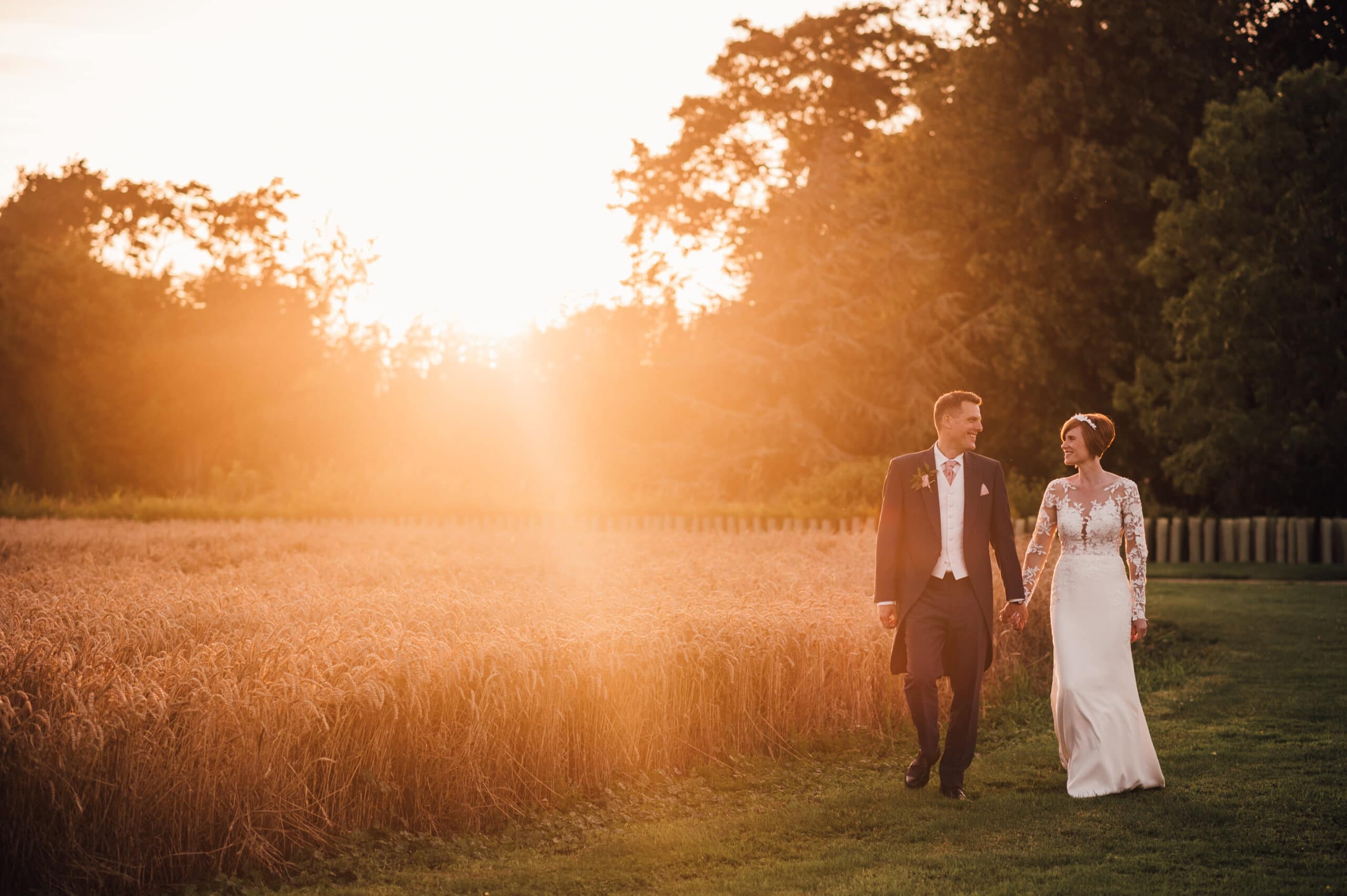 Newlywed Bride and Groom enjoying a walk in the grounds during their wedding at Bassmead Manor Barns in Cambridgeshire