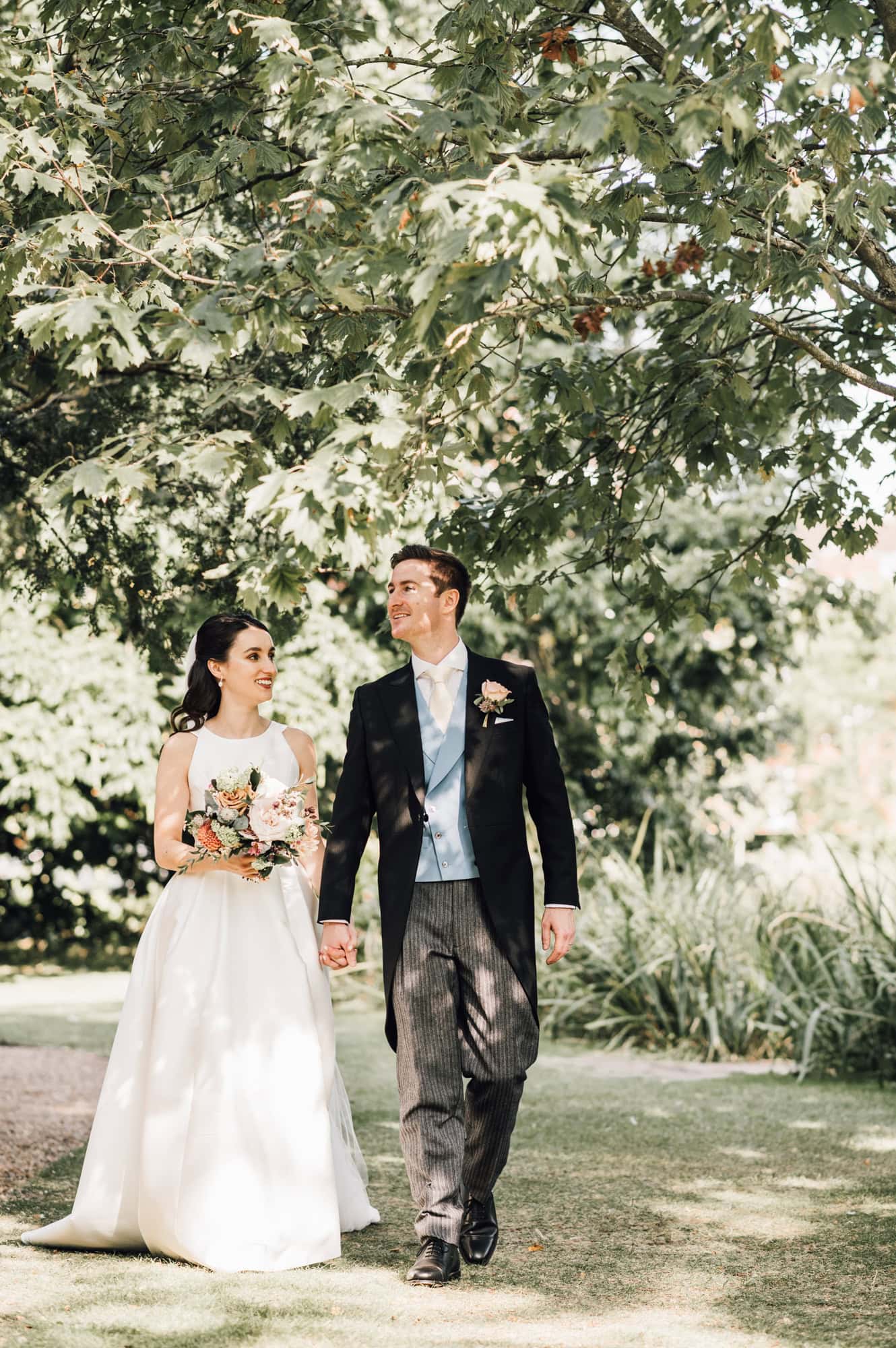 Bride and Groom walking the gardens at Emmanuel College Wedding in Cambridge