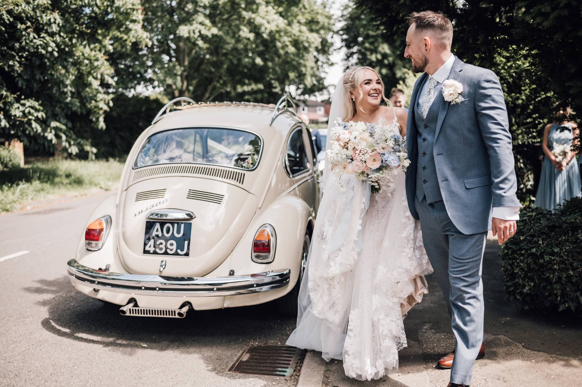 Bride and Groom next to a cream VW car from Luck Penny Weddings