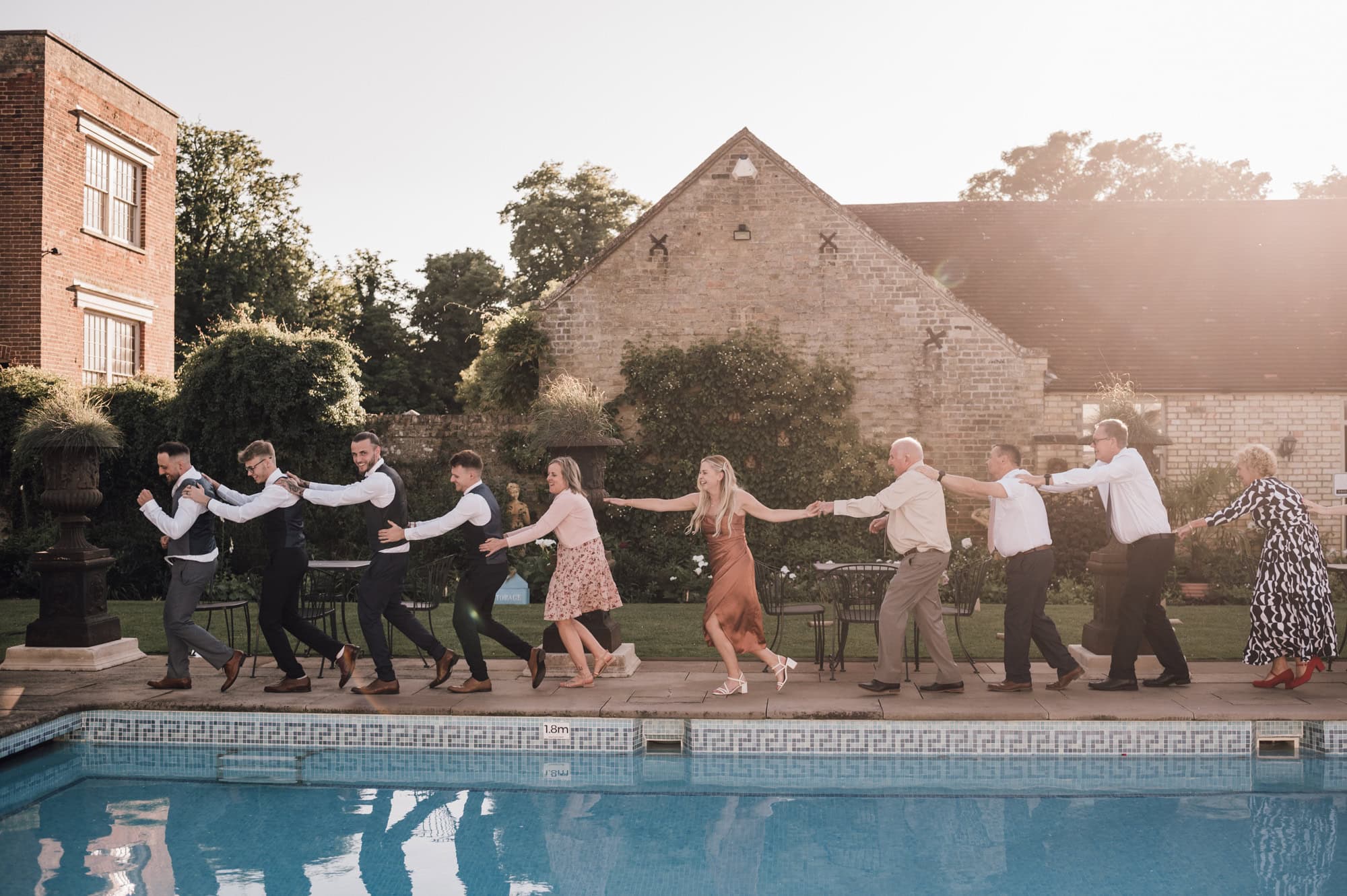 Guest doing conga around the pool at Shortmead House Wedding venue in Bedfordshire