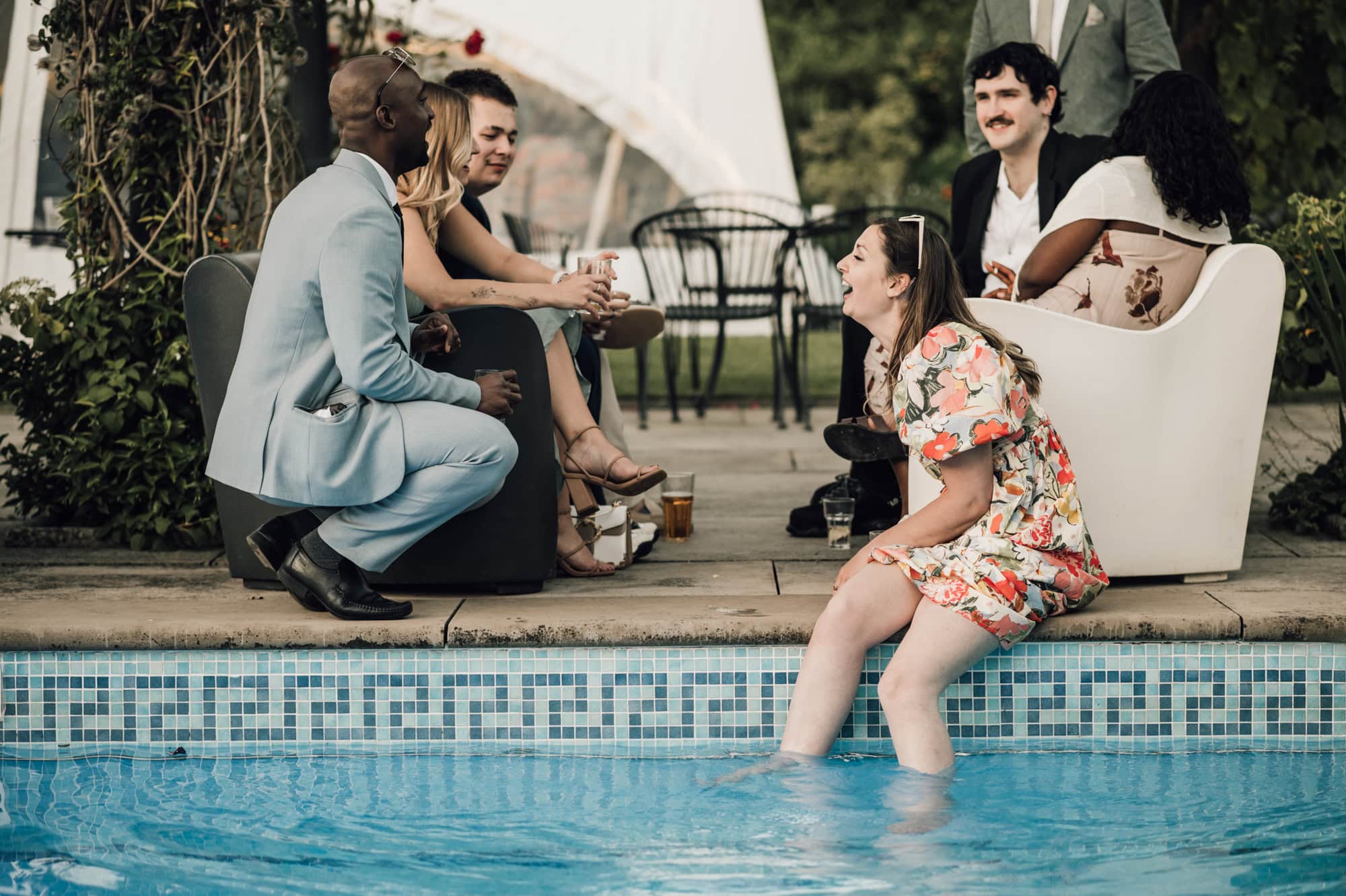 Wedding guest laughing around the pool at Shortmead house Wedding