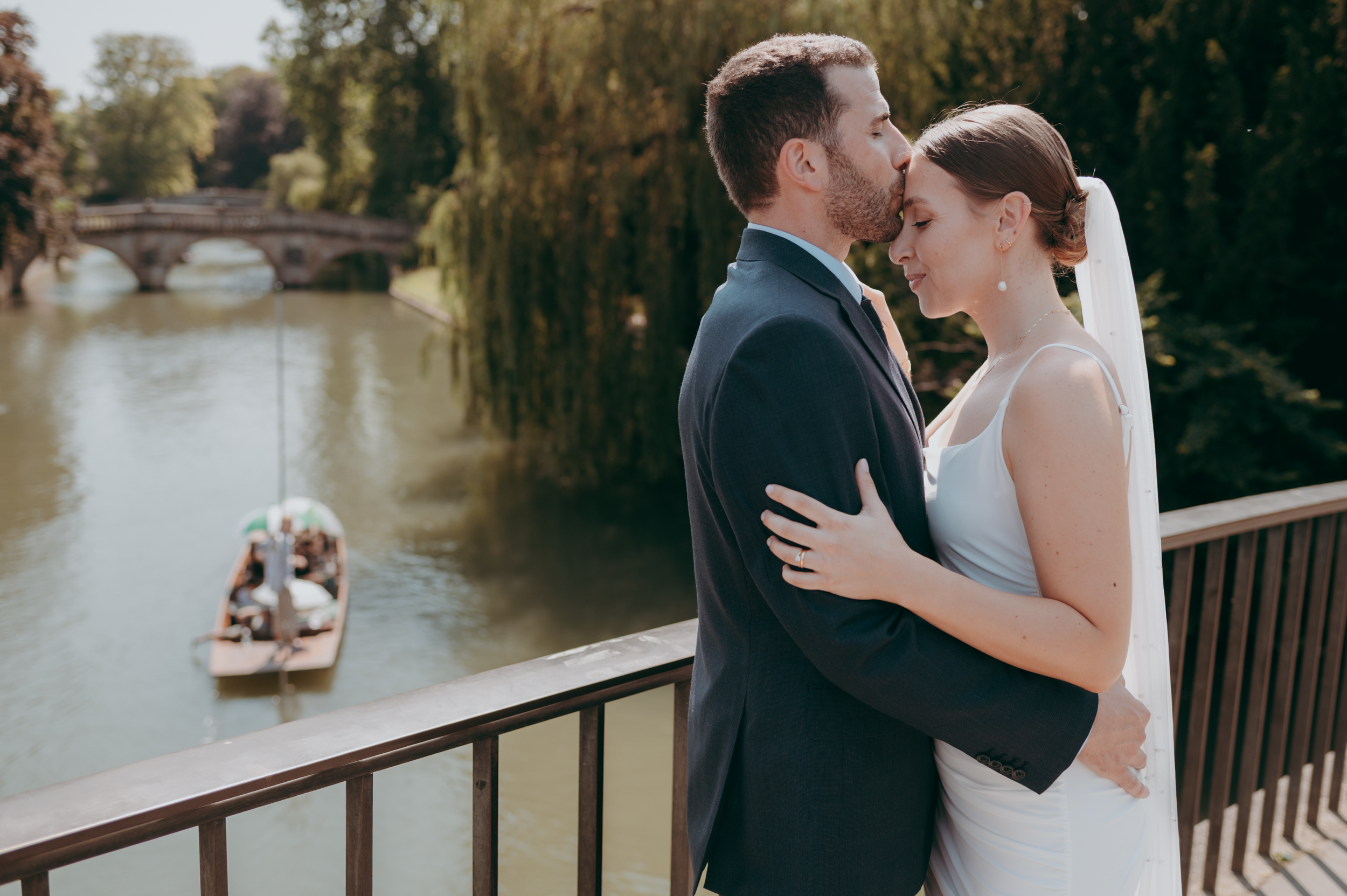 Bride and groom portrait on Silver Street bridge in Cambridge with punting on the river Cam behind