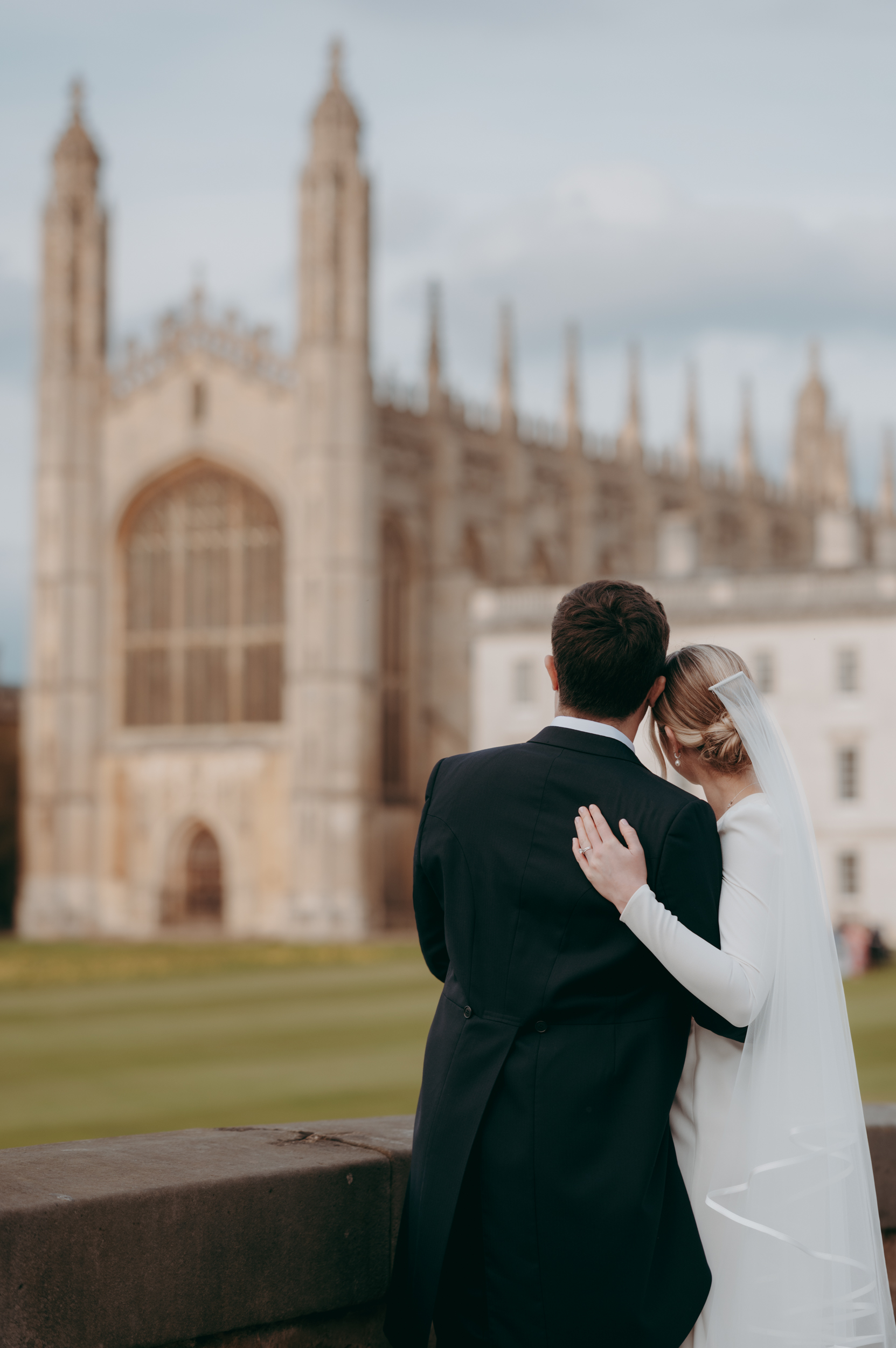 Bride and groom from behind as they look back toward King's College chapel in Cambridge