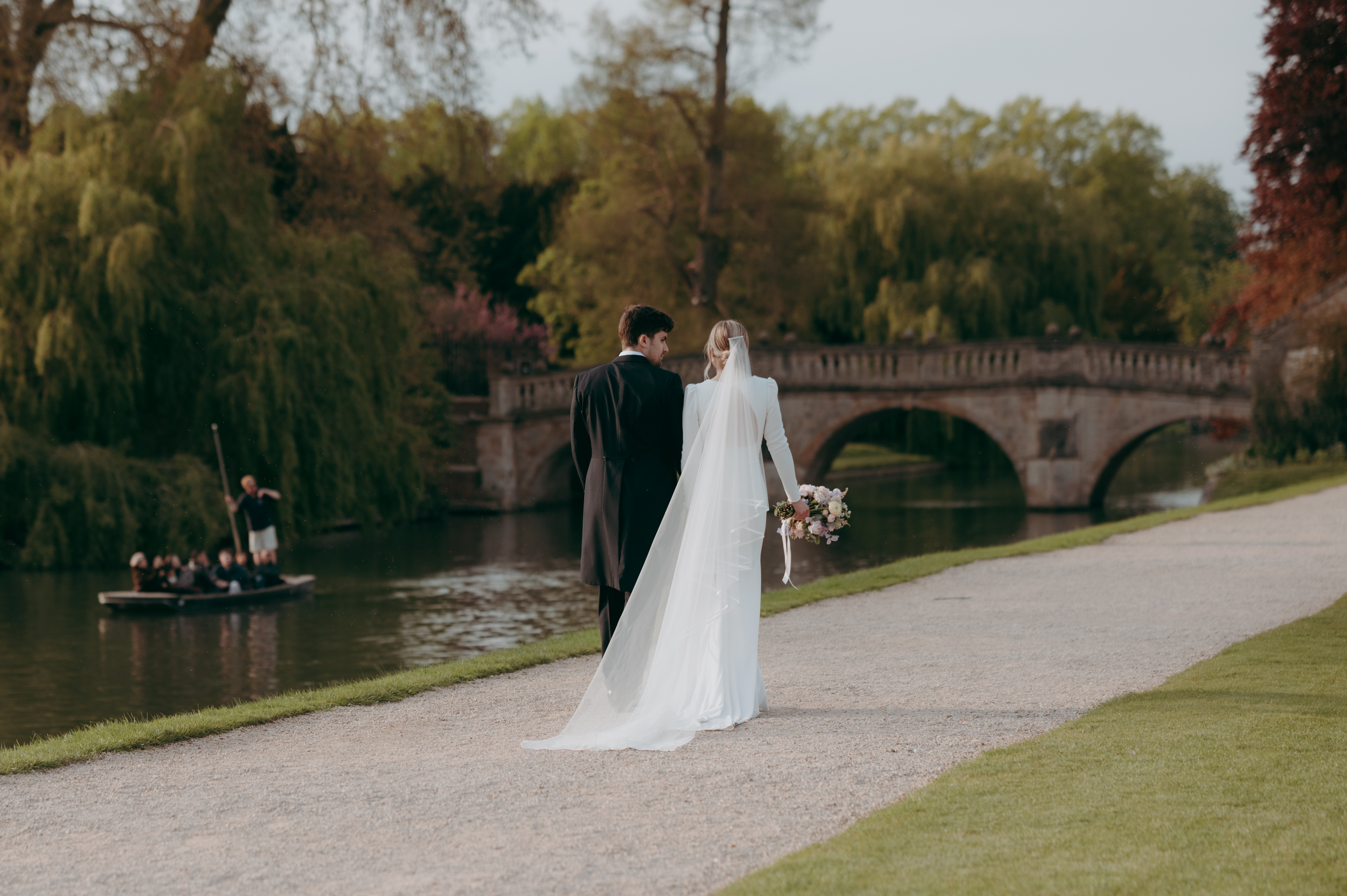 Couple walking the banks of the River Cam at Cambridge Wedding