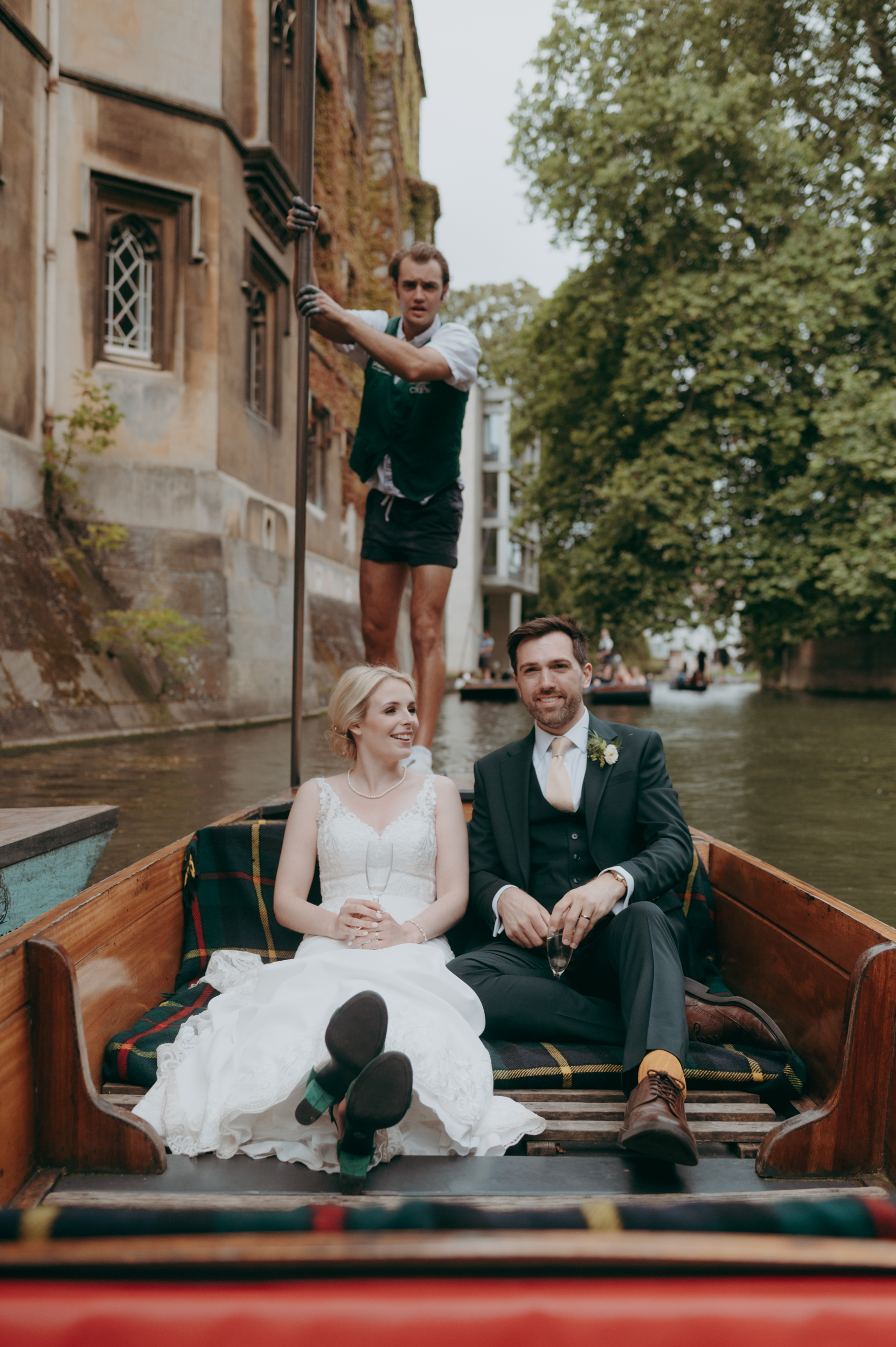 A bride and groom having photos while punting on the Cam as part of their wedding in Cambridge