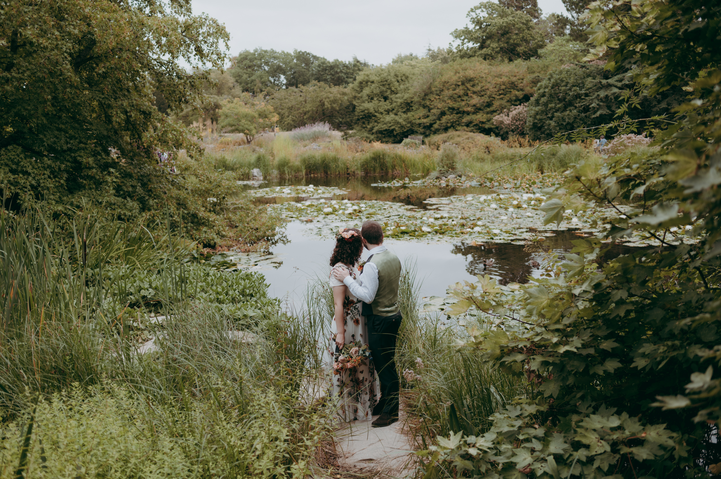 Newlywed couple surrounded by the greenery of the Botanical Gardens in Cambridge